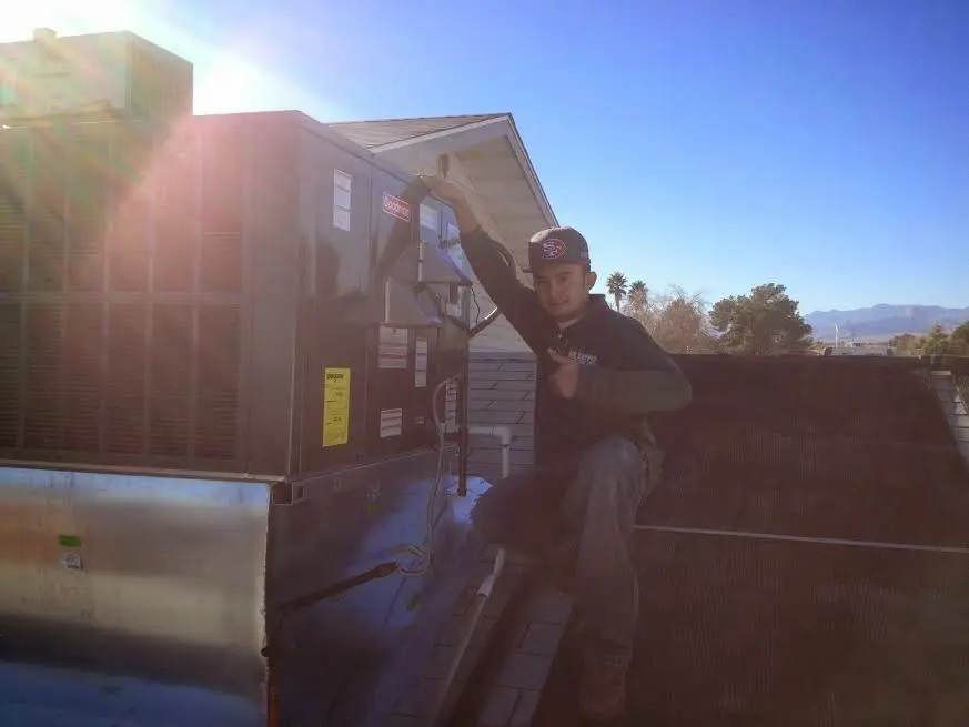 HVAC technician performing HVAC Inspection on a rooftop unit in Ashland
